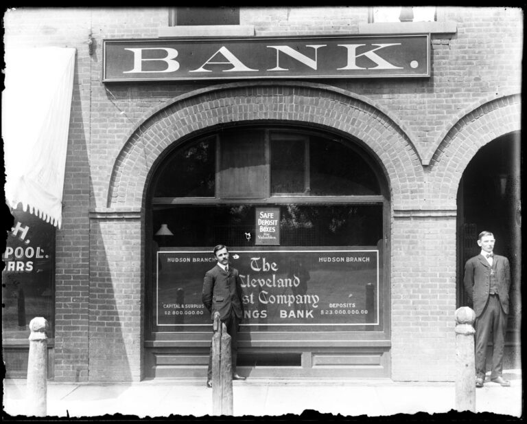 Exterior of the The Cleveland Trust Company Savings Bank, Hudson branch. Two unidentified men standing in front of building