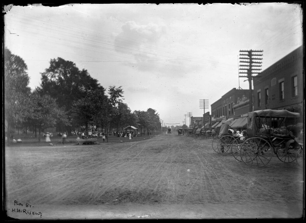 Main Street and the Green, view south during Home Day. In lower left corner: "Photo by H.W. Rideout."