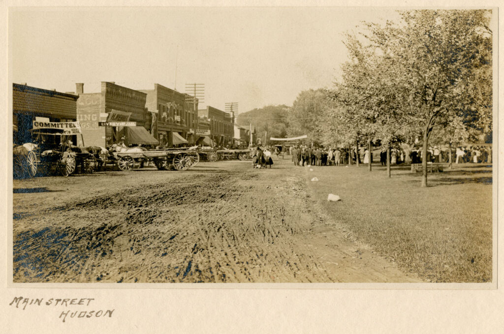 Main Street, looking north, on Home Day. People gathered on streets and in the Green. Handwritten caption at bottom reads, "Main Street Hudson"