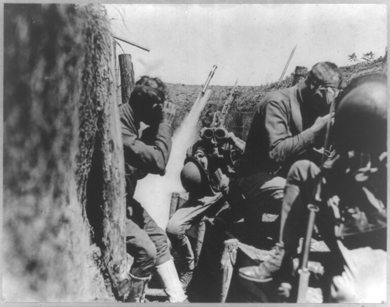 U.S. soldiers in trench putting on gas masks, World War I